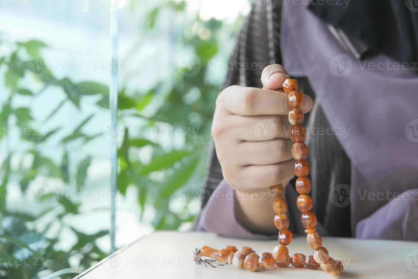 Frauenhände beten mit Perlen foto