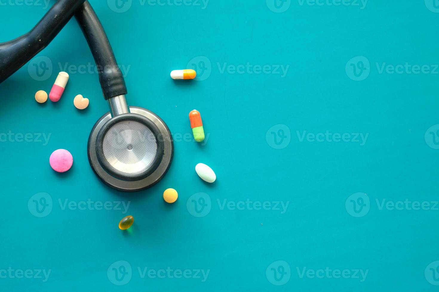 bunte Pillen und Stethoskop auf grünem Hintergrund foto