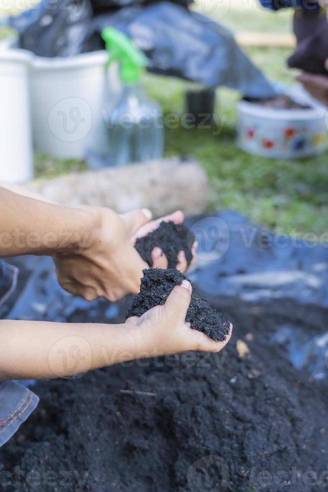 wenig Kind Hände halten Fülle Boden zum Landwirtschaft oder vorbereiten zu Pflanze testen Boden Proben auf Hände mit Boden Boden Hintergrund. Schmutz Qualität und Landwirtschaft Konzept. foto