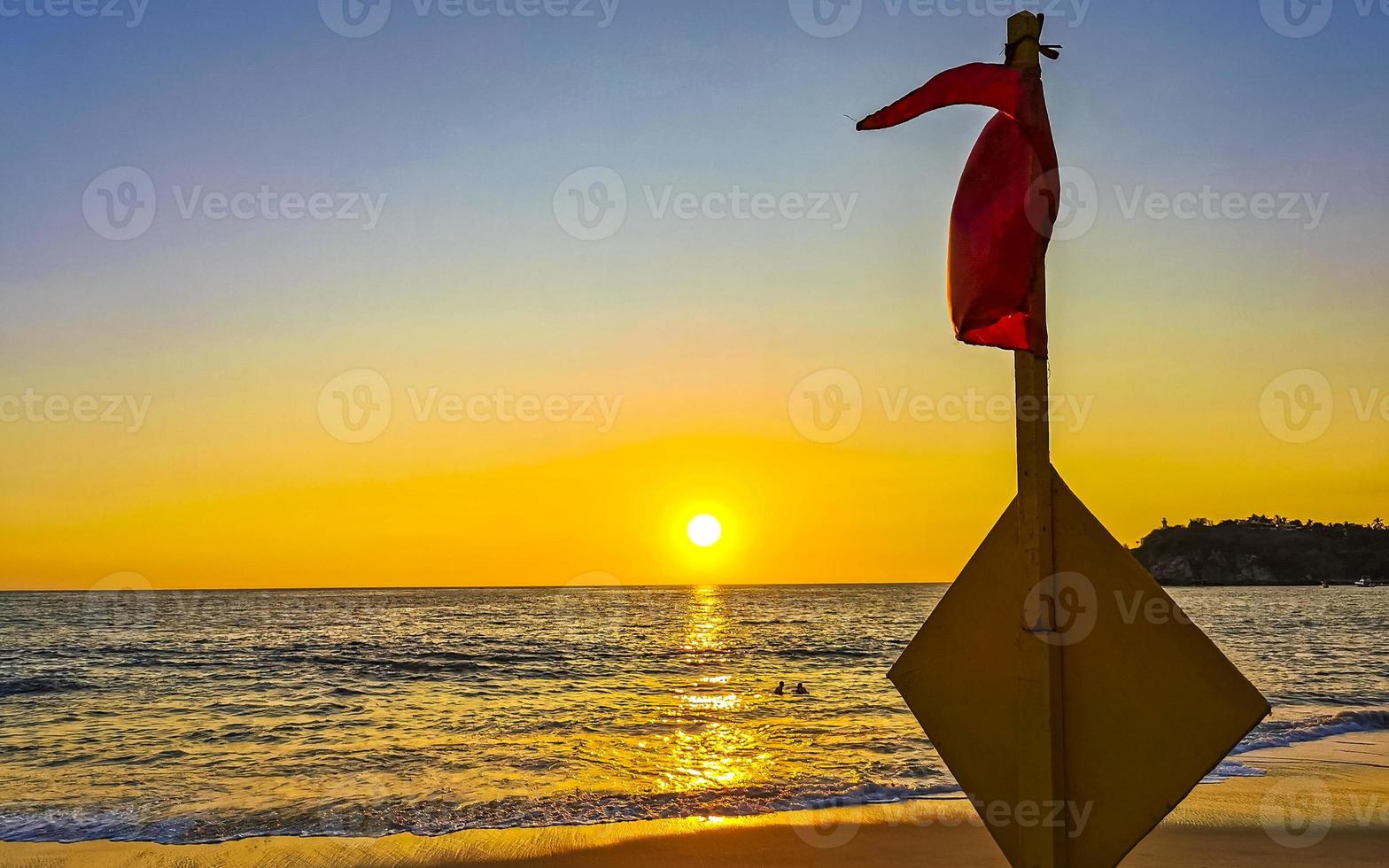 rot Flagge Schwimmen verboten hoch Wellen mit Sonnenuntergang im Mexiko. foto