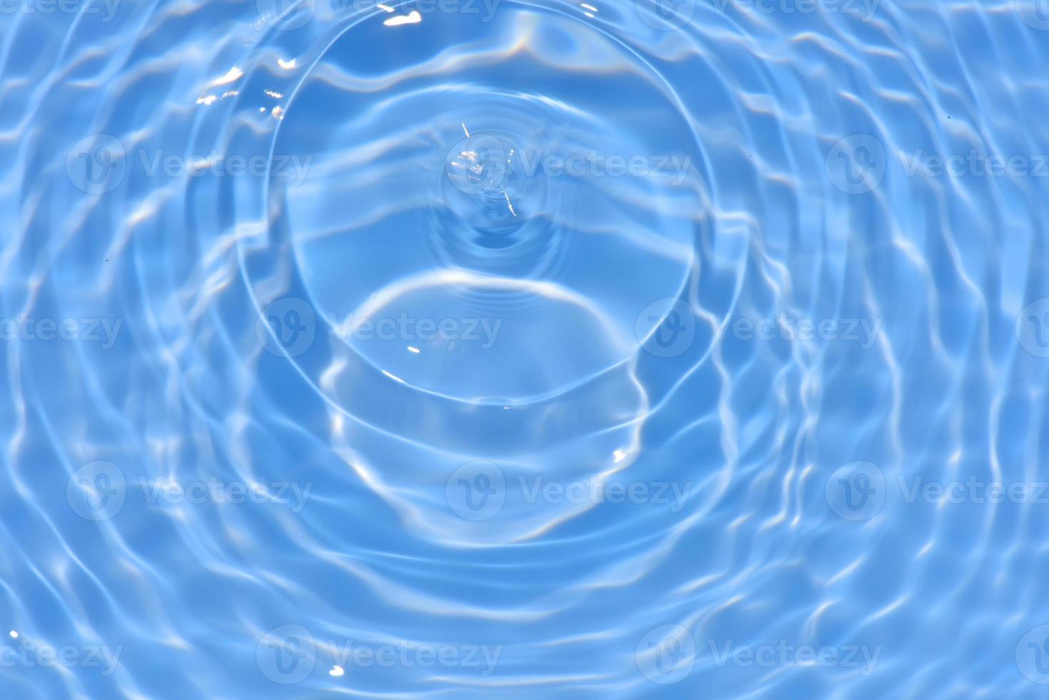 defocus verschwommene, transparente, blaue, klare, ruhige wasseroberflächenstruktur mit spritzern und blasen. trendiger abstrakter naturhintergrund. wasserwellen im sonnenlicht mit kopierraum. blaues Wasser glänzt foto