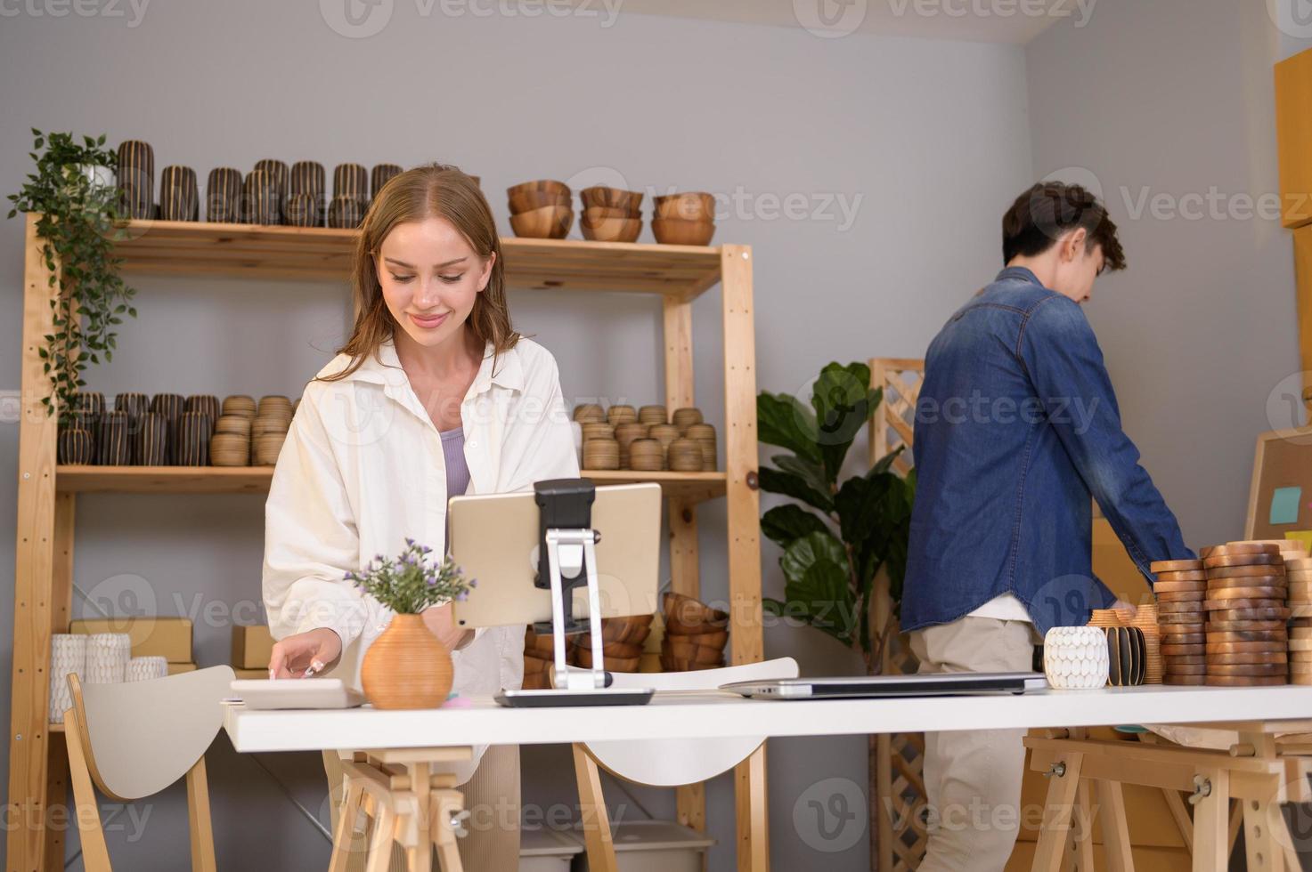 ein jung Paar Unternehmer Überprüfung und Verpackung Kunst Produkte Verkauf zu Kunden im Sie Geschäft foto