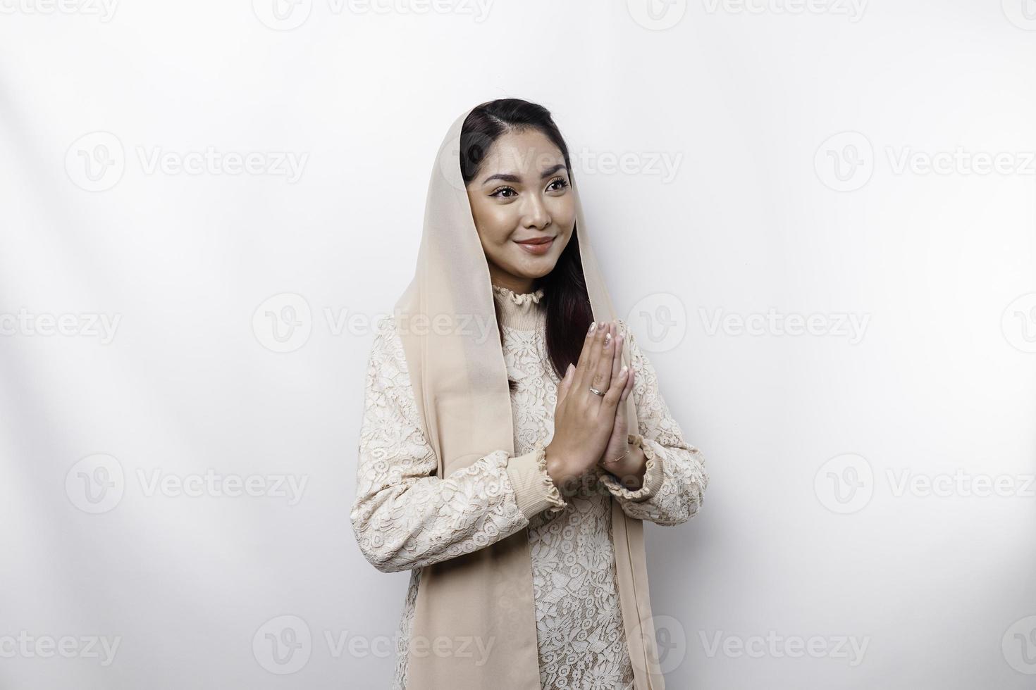 Porträt von ein jung schön asiatisch Muslim Frau tragen ein Kopftuch gestikulieren eid Mubarak Gruß foto