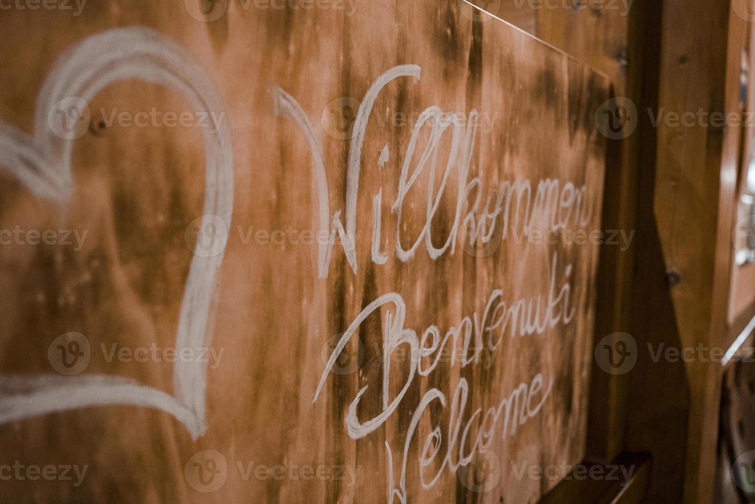 Herz gestalten mit Text geschrieben auf hölzern herzlich willkommen Tafel foto