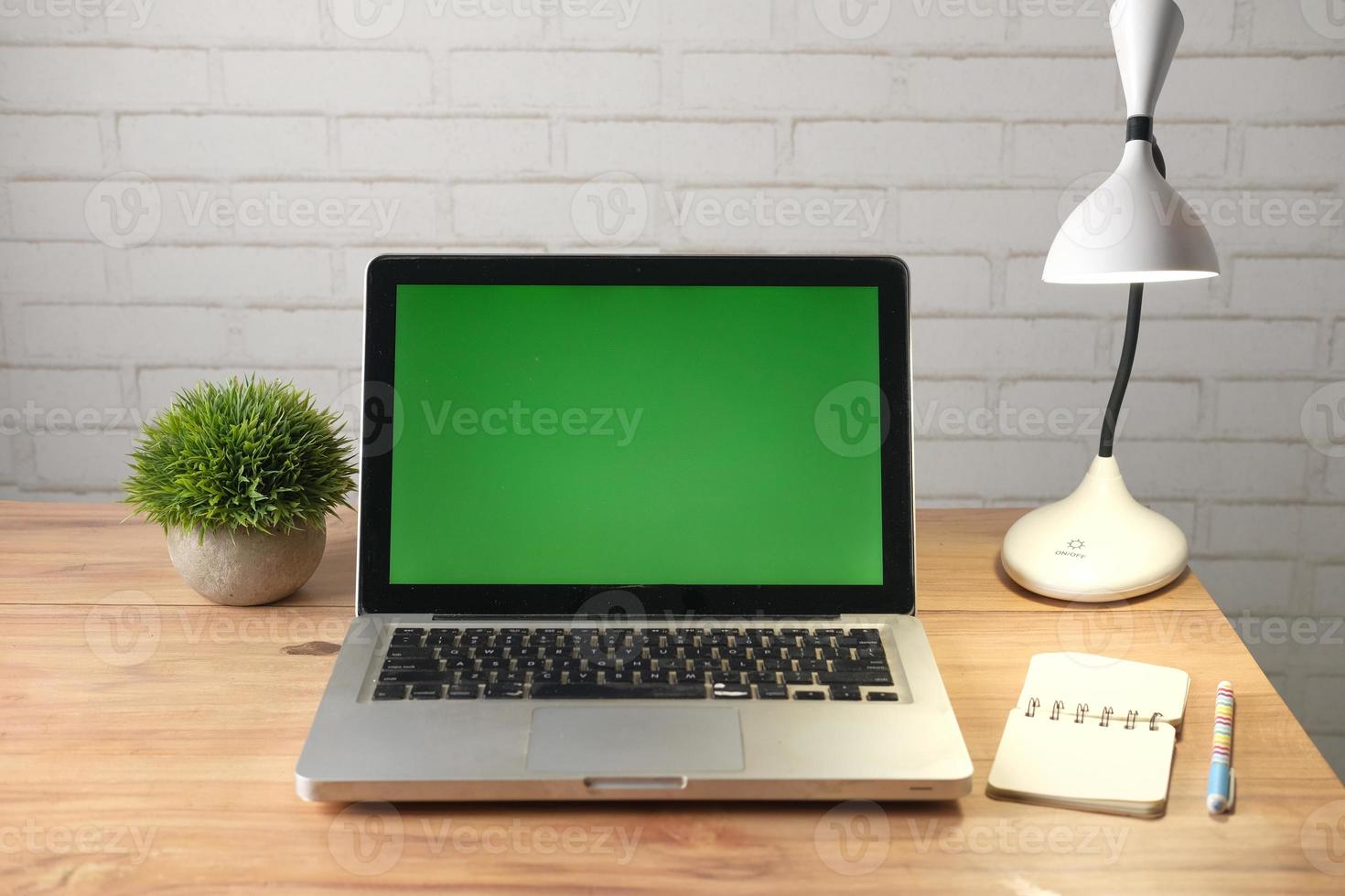 Laptop mit grünem Bildschirm am Schreibtisch foto