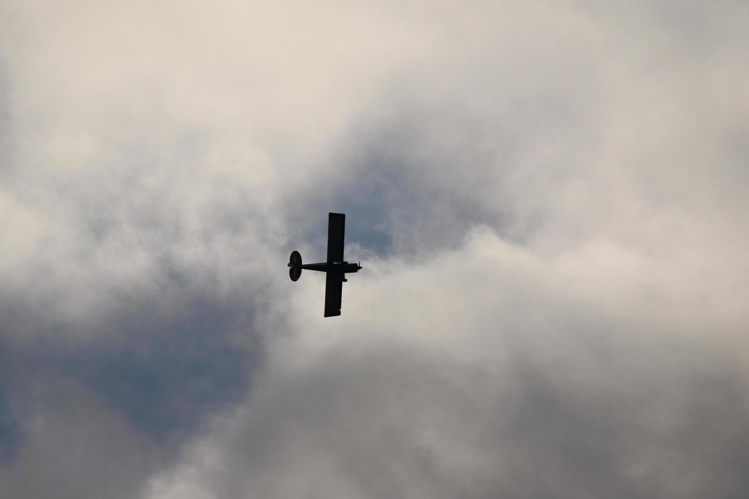 klein Flugzeug fliegend im das Himmel gegen dunkel Wolken foto