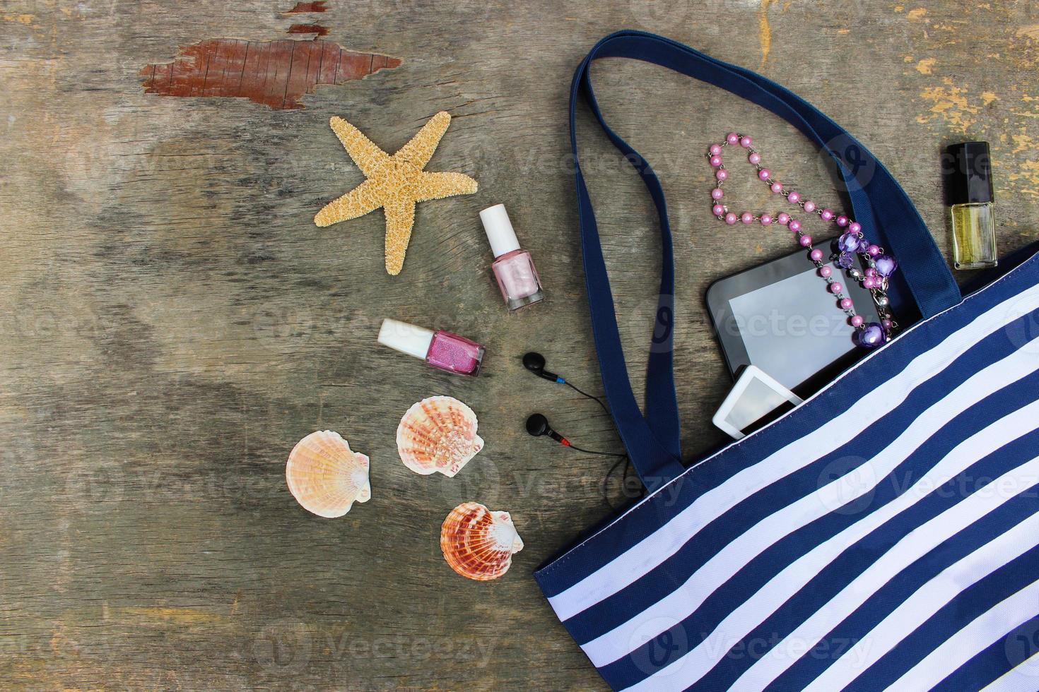 Strand Tasche, Kosmetika und Damen Zubehör auf alt hölzern Hintergrund. oben Sicht. foto