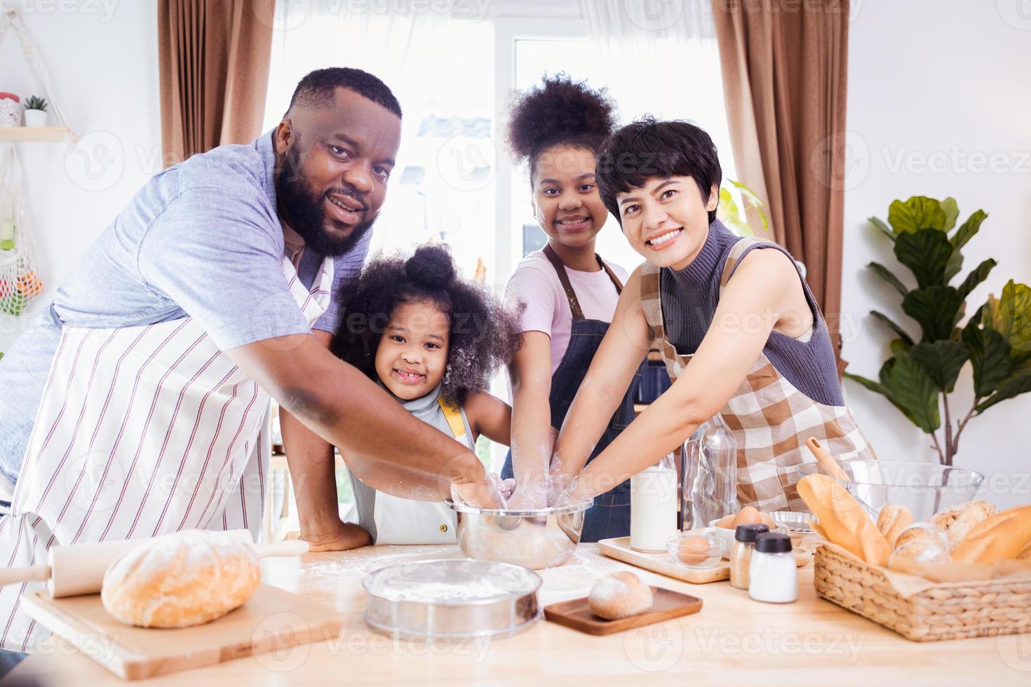 glücklich afrikanisch amerikanisch Familie genießen zusammen während bereiten das Mehl zum Herstellung Kekse beim Zuhause foto