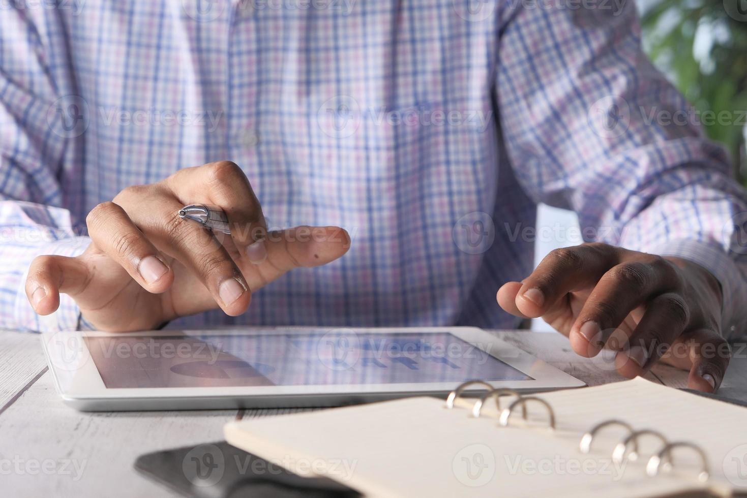 Männerhand, die an digitalem Tablett am Schreibtisch arbeitet foto