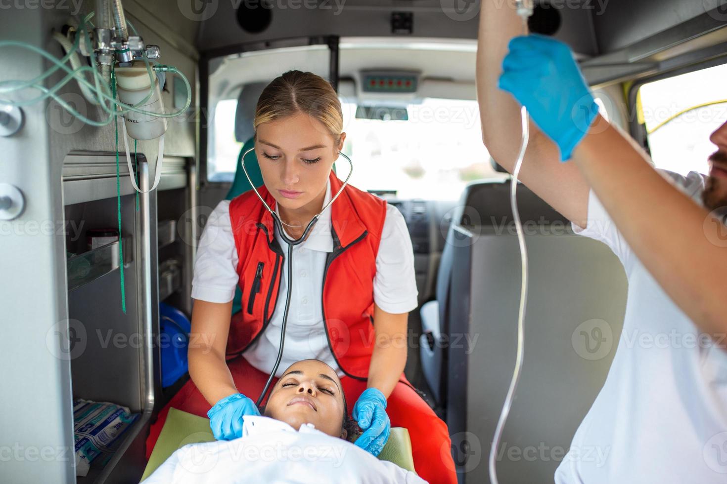 Mediziner mit verletzt geduldig geben ein Infusion . jung männlich Sanitäter halten iv Lösung. weiblich Arzt Auflistung Herz von geduldig foto