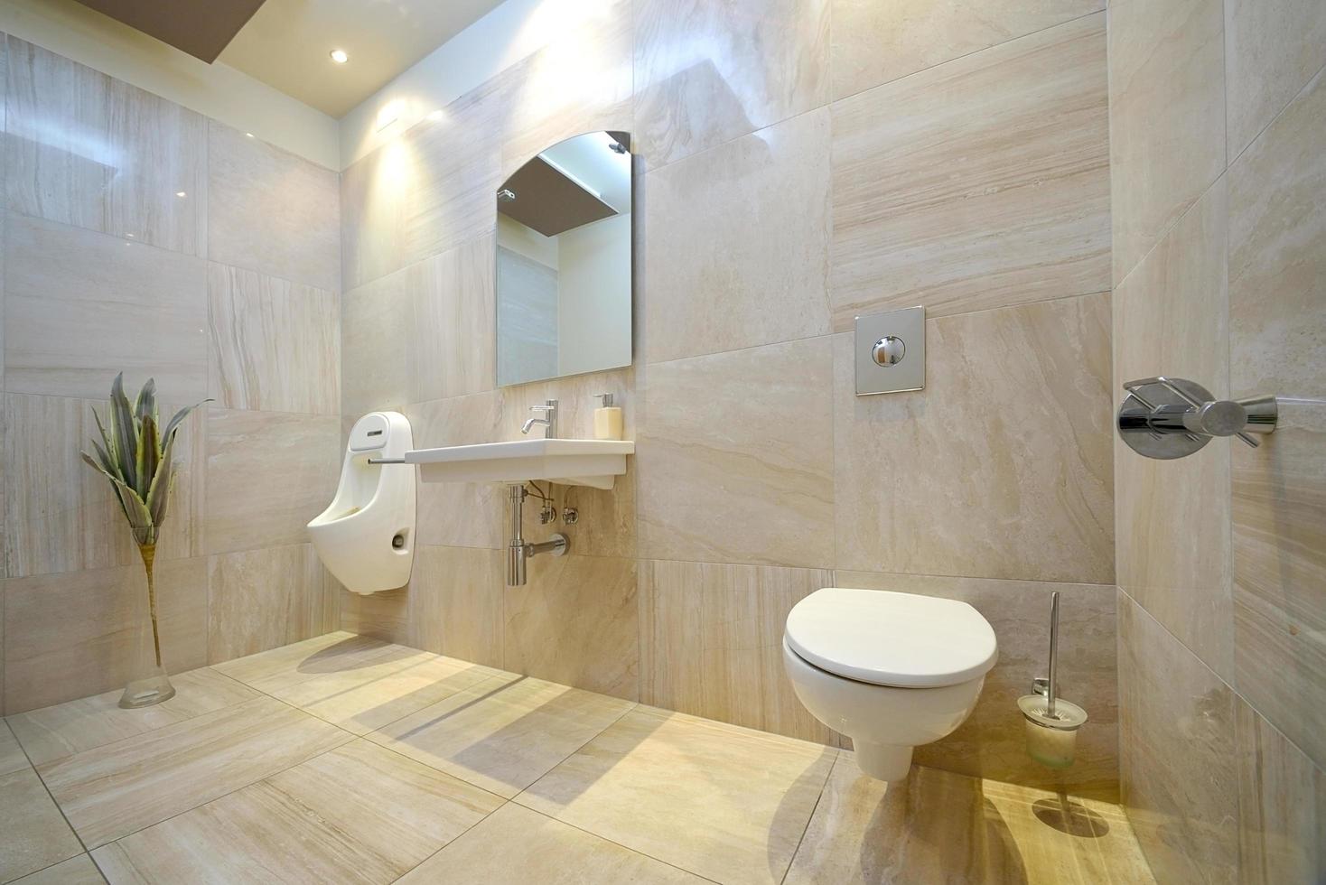 moderne beige Toilette mit Toilette, Waschbecken, Spiegel und Bidet foto