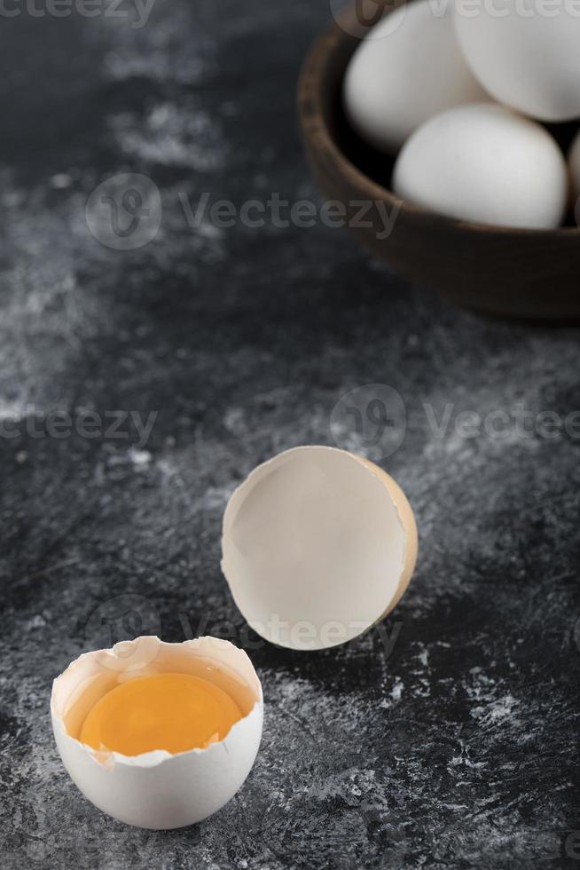 Schüssel mit weißen Eiern und Eigelb auf einem Marmorhintergrund foto