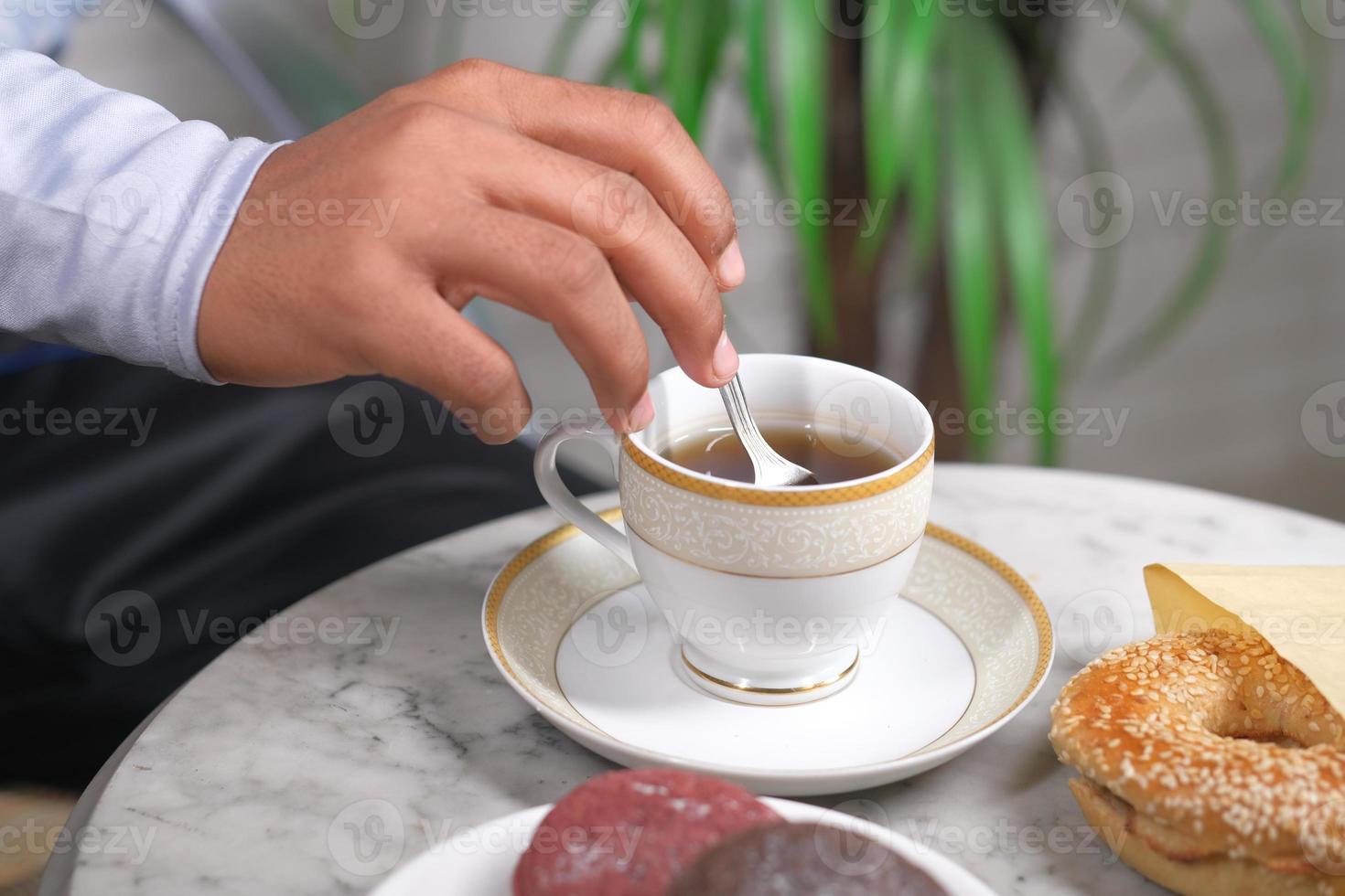 Person, die Kaffee mit Löffel rührt foto