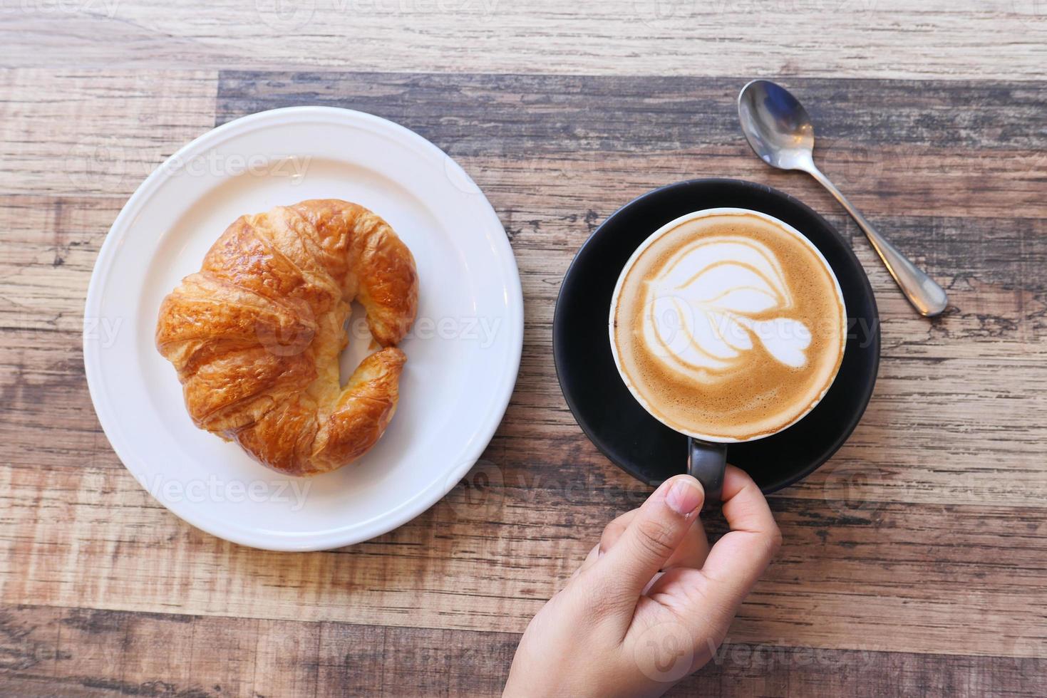 Kaffee und Croissant auf Holztisch, Draufsicht foto