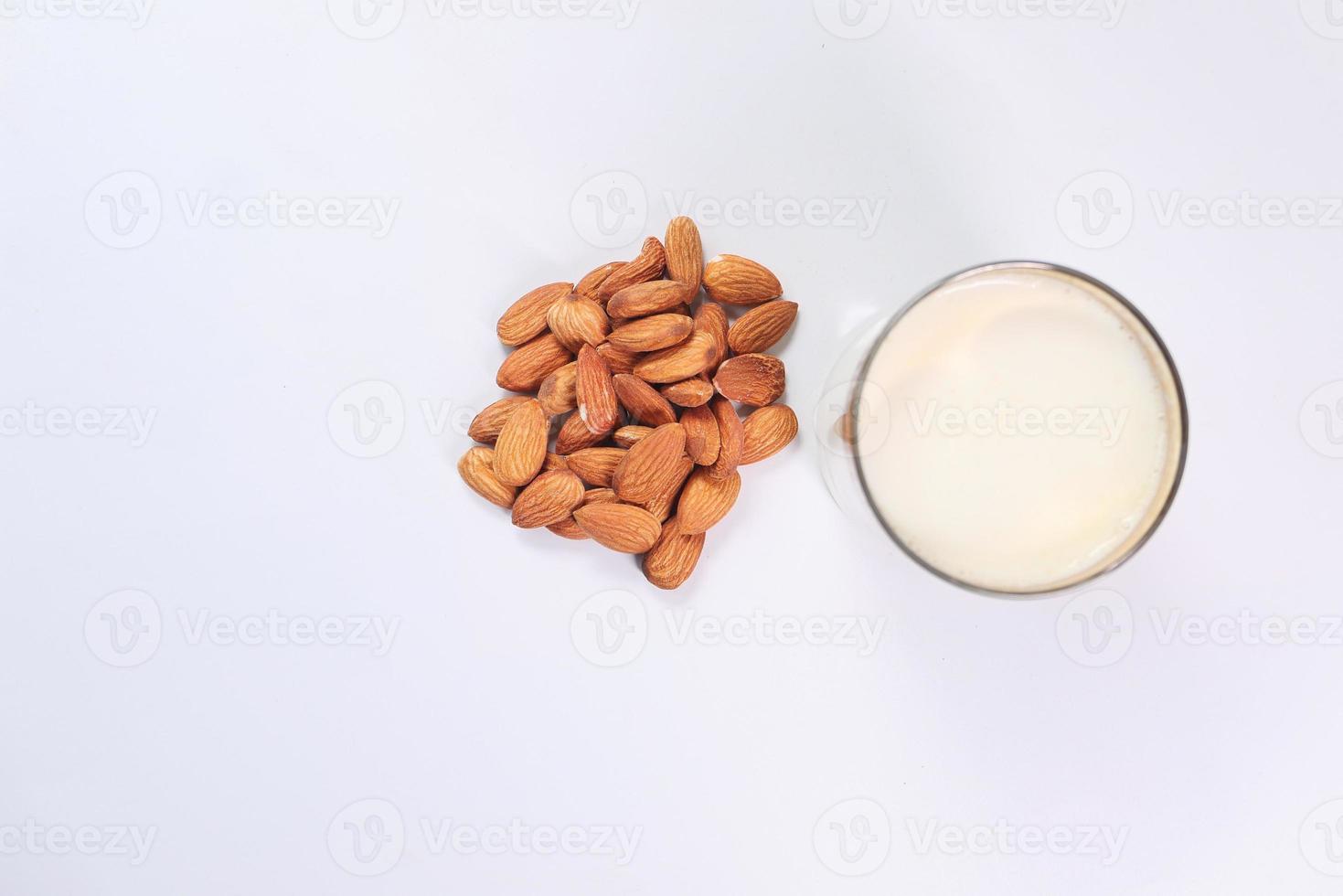 Mandeln und ein Glas Milch auf weißem Hintergrund foto