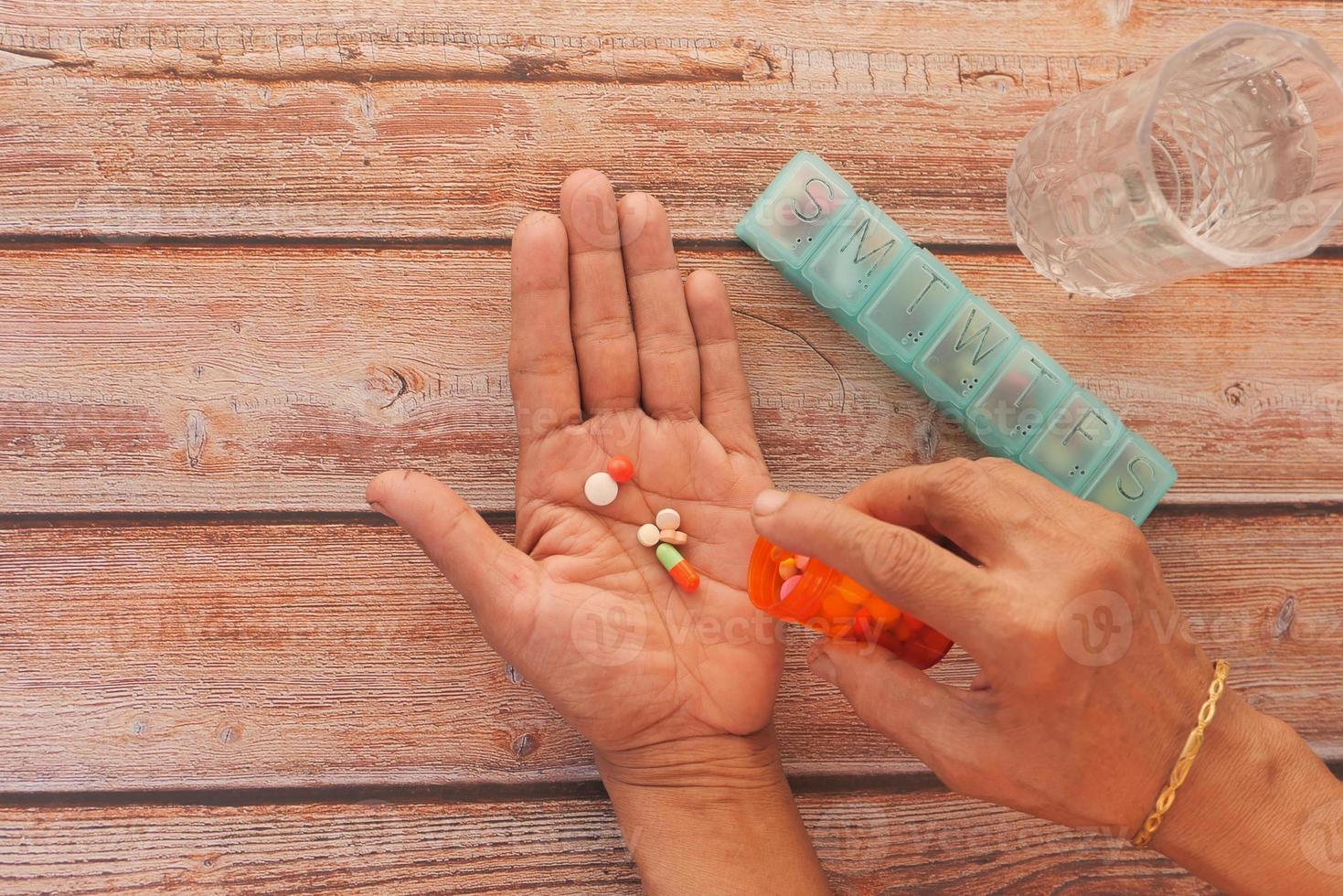 Frau, die tägliche Medizin auf neutralem Hintergrund nimmt foto