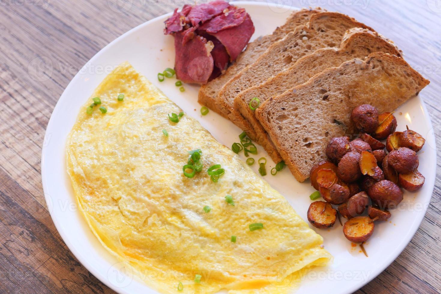 Omelett, Toast und Kartoffeln zum Frühstück foto