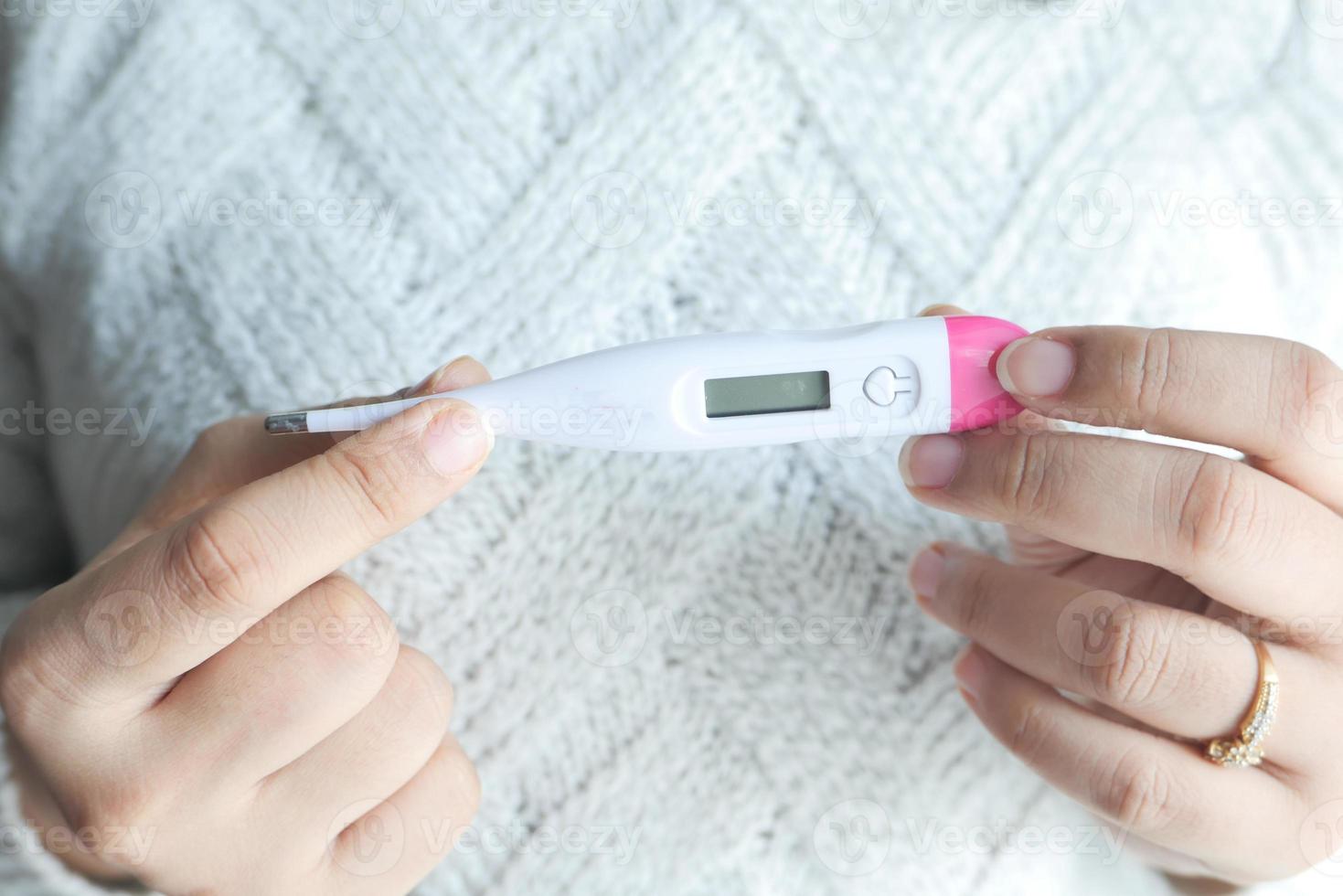 Nahaufnahme der Hand der Frau, die digitales Thermometer hält foto