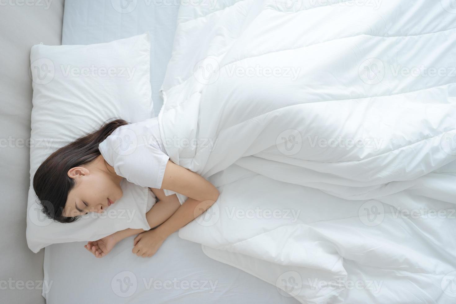 jung Frau Schlafen im ein komfortabel Weiß Schlafzimmer. foto