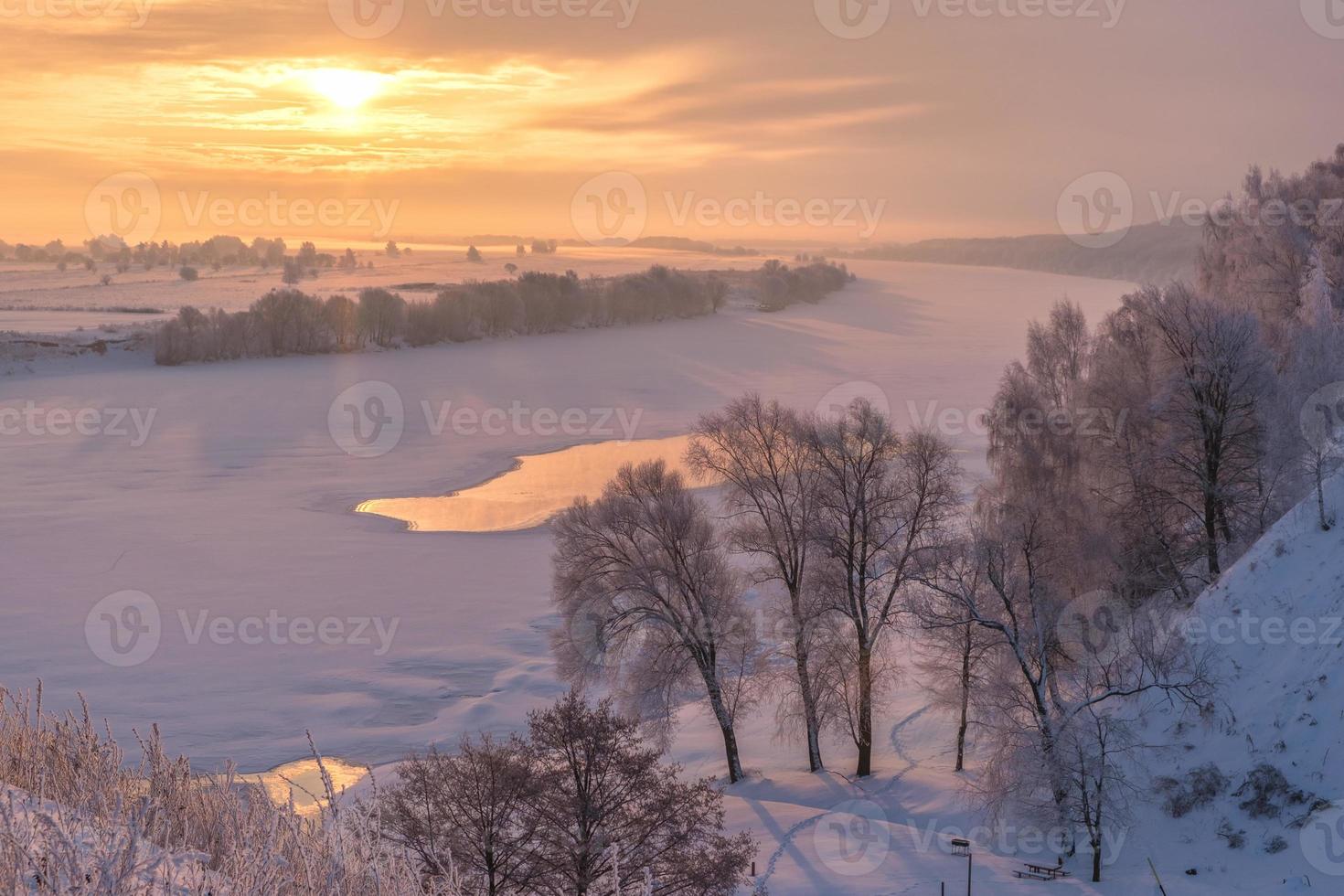 schöne Winterlandschaft mit Sonnenaufgang über dem Fluss foto