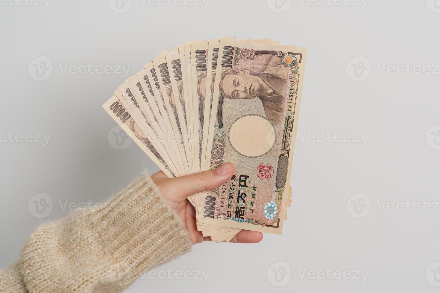 Frauenhand, die Banknotenstapel des japanischen Yen hält. Tausend Yen Geld. japanische bargeld-, steuer-, rezessionswirtschafts-, inflations-, investitions-, finanz- und einkaufszahlungskonzepte foto