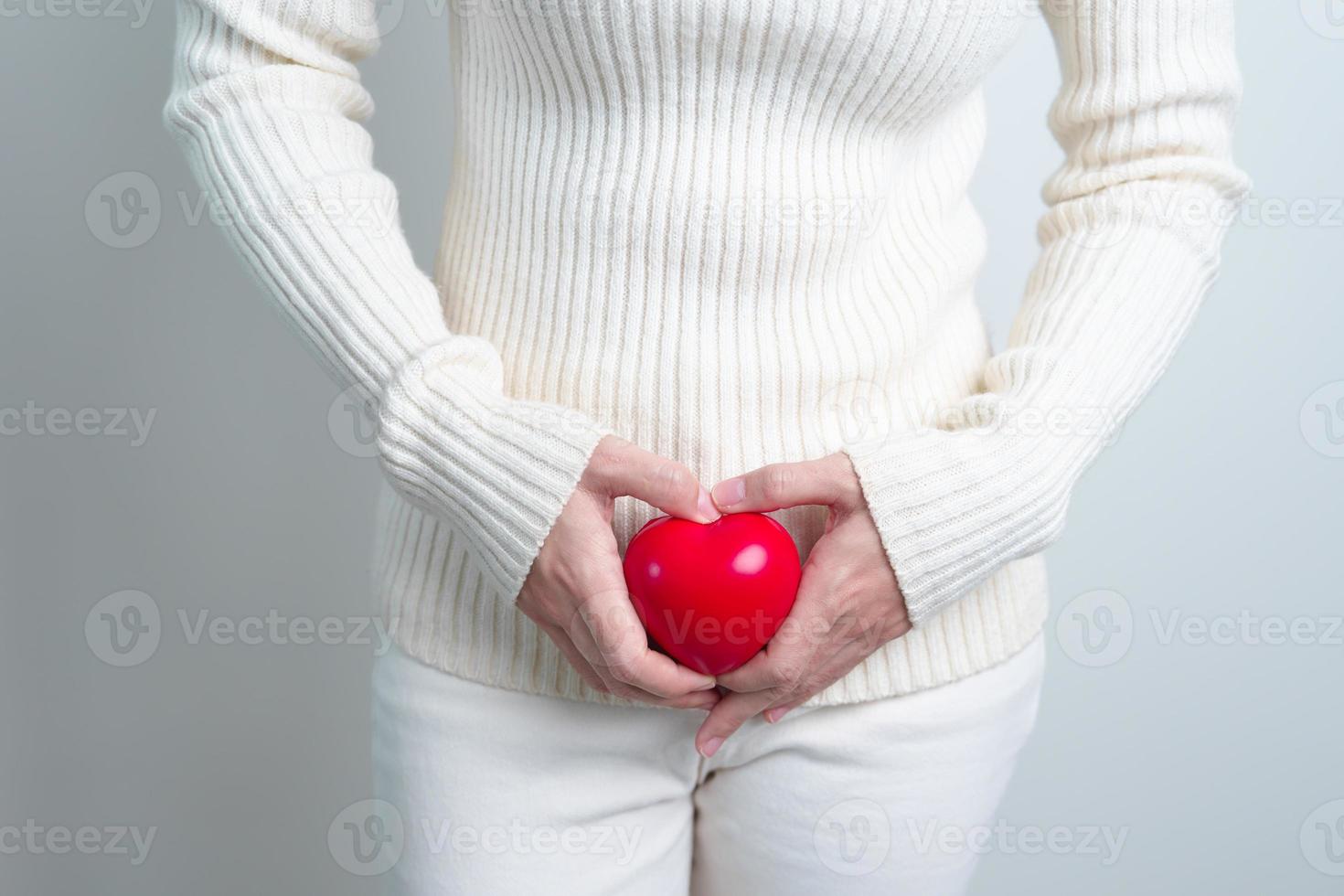 Frau mit roter Herzform. Konzept für Schwangerschaft, Fortpflanzungssystem, Menstruation und Gynäkologie foto