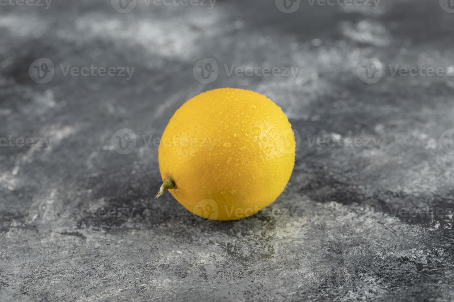 eine gelbe reife Zitrone auf einem Marmorhintergrund foto