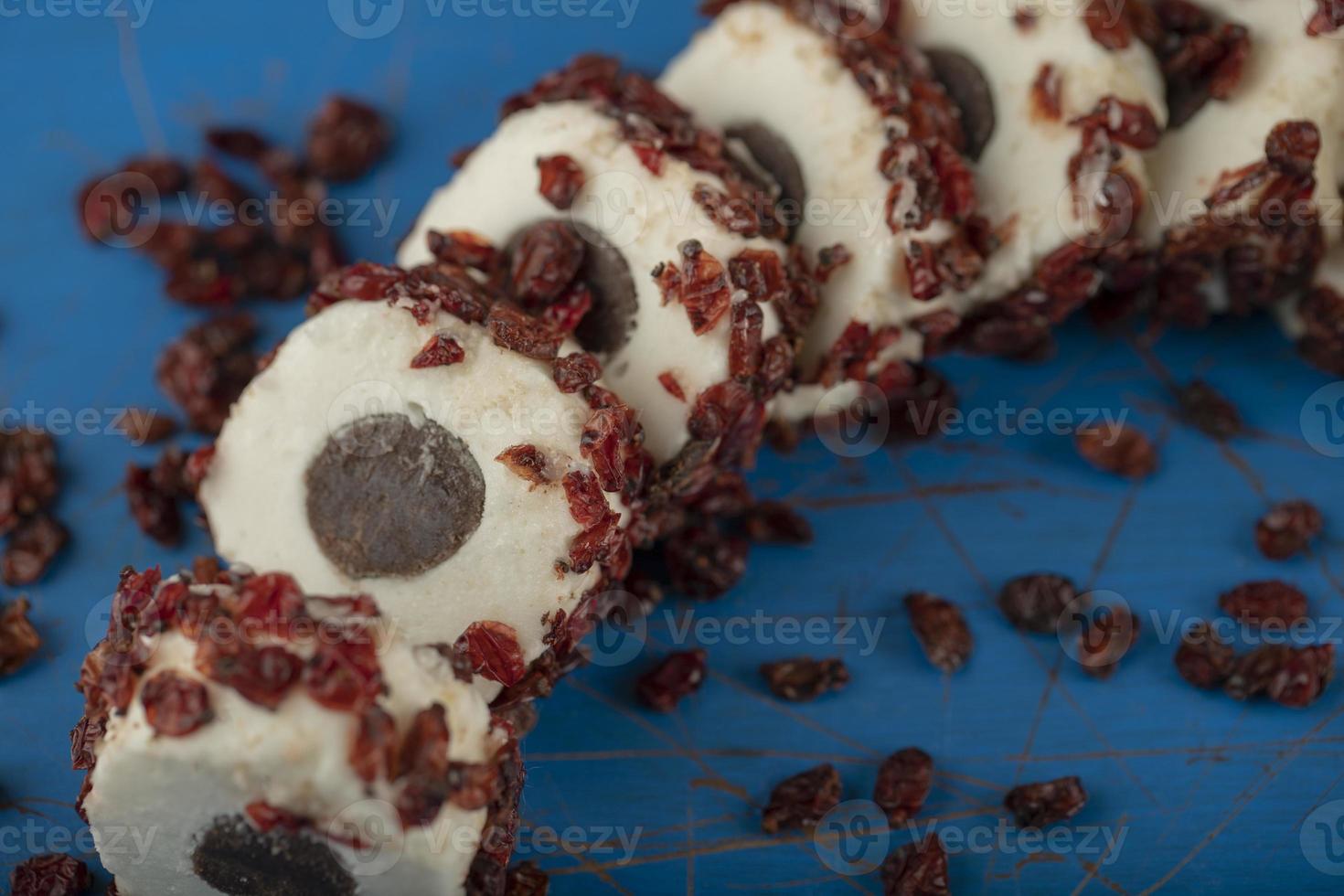 süß geschnittenes Dessert mit getrockneten Früchten auf einem blauen Holzbrett foto