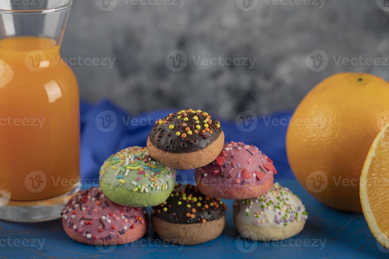 bunte süße Donuts mit einem Glas Saft foto