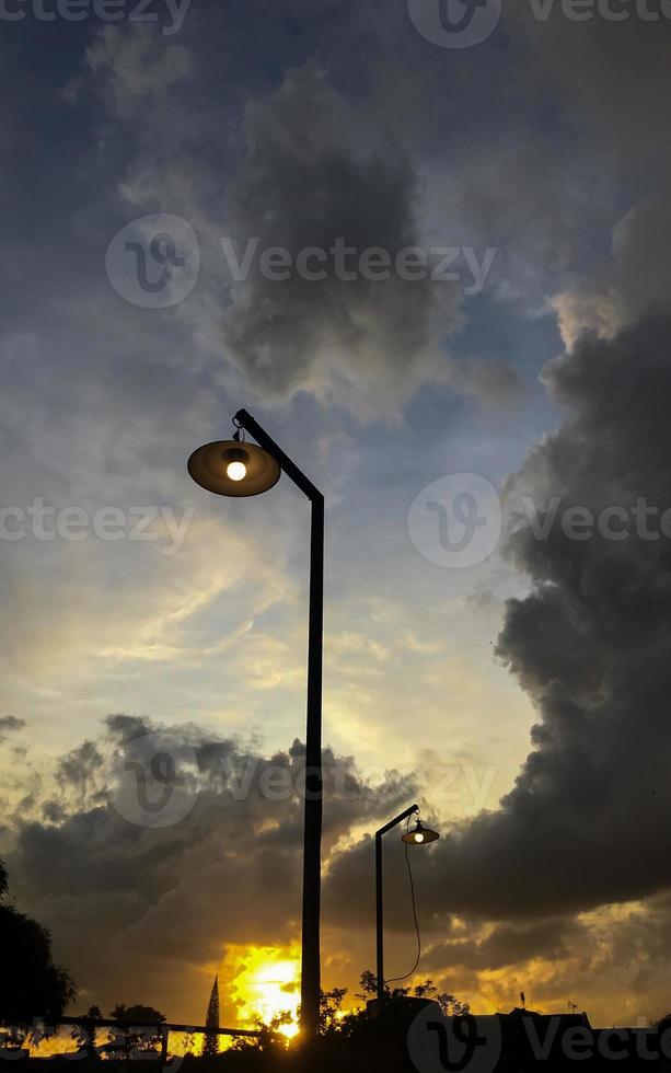 Silhouette von Beleuchtung gegen ein Hintergrund von Wolken und Sonnenuntergang foto