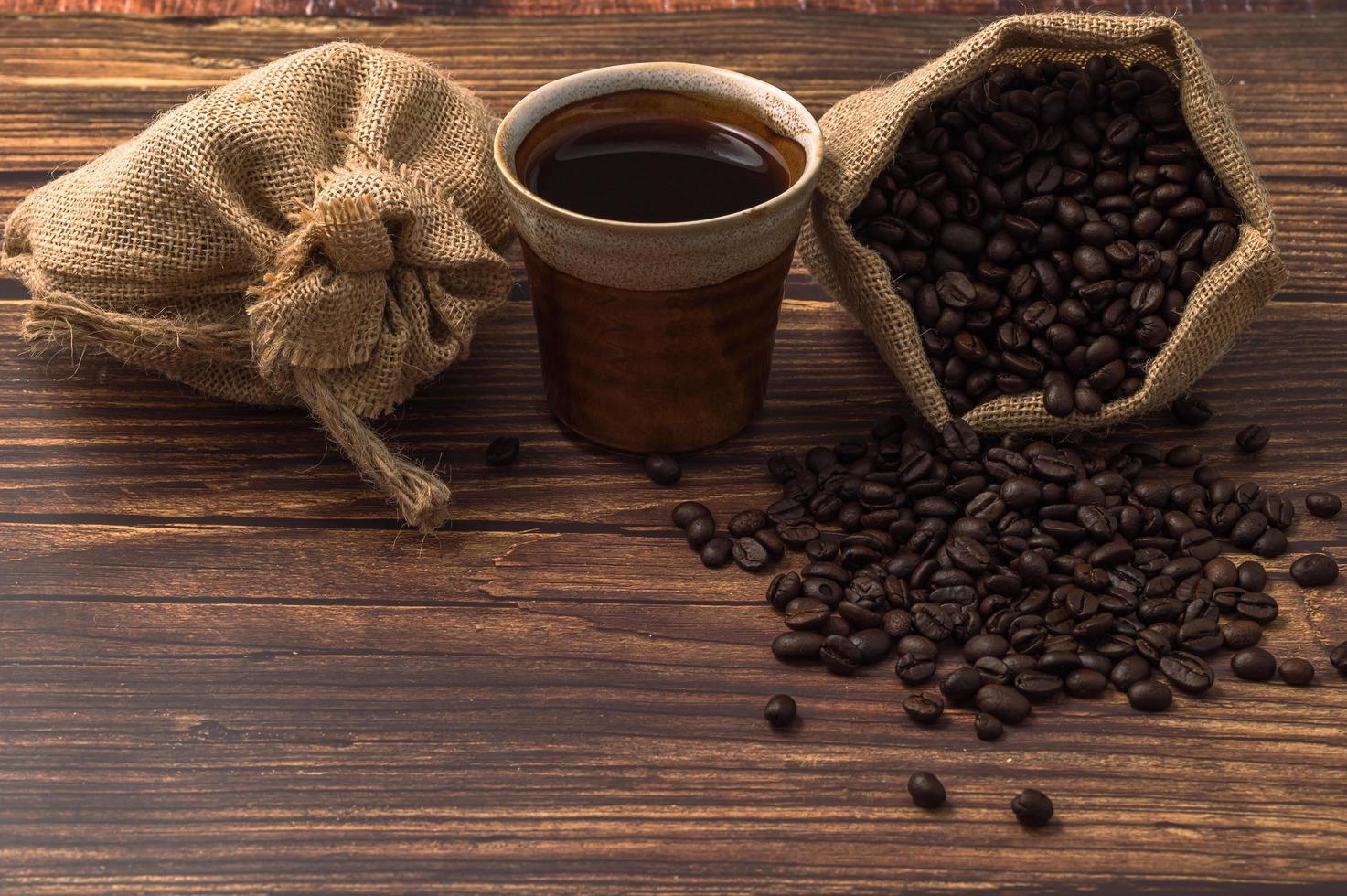 eine Kaffeetasse und Kaffeebohnen auf einem Holztisch, lieben Kaffeekonzept foto