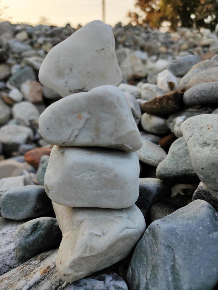 Stapel von dreieckig Steine.Gruppe von Weiß und bunt Steine.Kiesel Turm auf das Steine meer.steine Pyramide auf Kieselstein Strand symbolisieren Stabilität,Zen,Rock,Harmonie,Gleichgewicht.flach Tiefe von Feld. foto