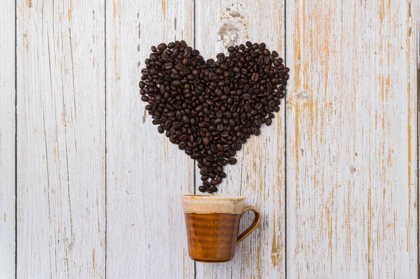 Kaffeebohnen in einer Herzform angeordnet, lieben das Kaffeetrinkkonzept foto