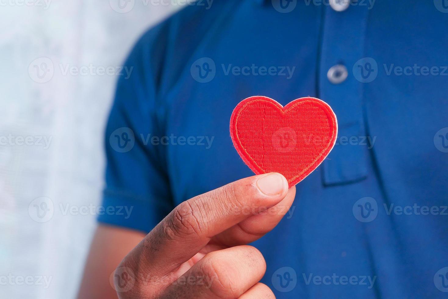 Mann hält rotes Herz foto