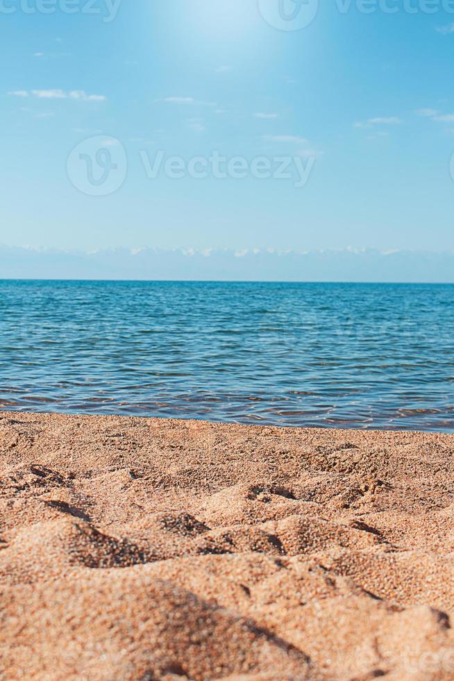 Strand mit uneben Sand und Meer. Sonne ist leuchtenden, hinter Berge. Vertikale. Freizeit, reisen, Urlaub. Kopieren Raum foto