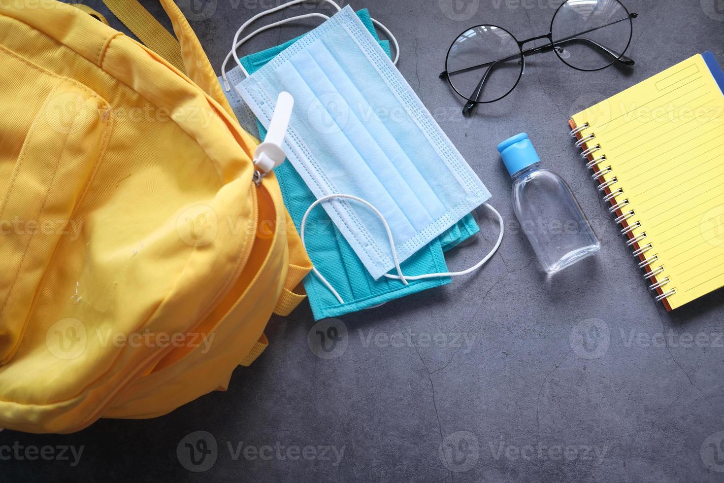 Schülertasche mit Desinfektionsmittel und Gesichtsmaske foto