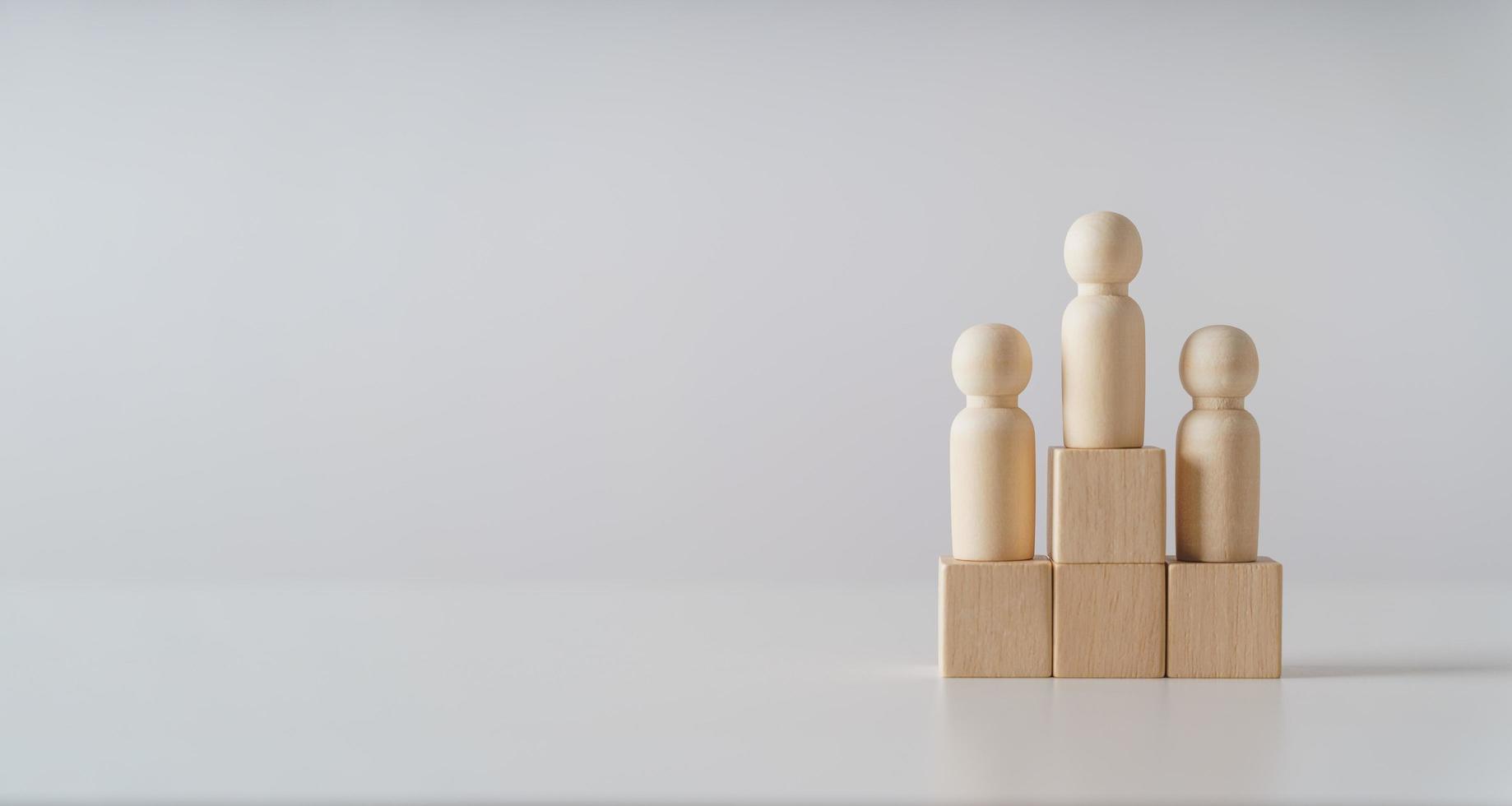 holzfiguren puppe steht auf dem podium aus holzwürfelblöcken mit kopierraum. Ranking- und Strategiekonzept. foto