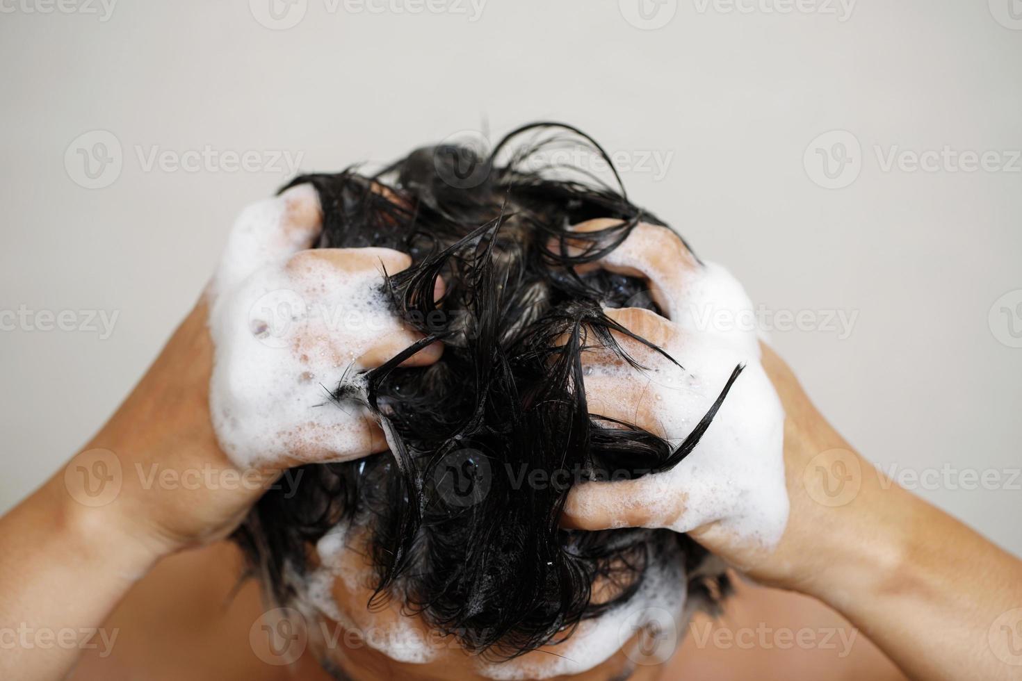 ein Mann ist Waschen seine Haar mit Shampoo foto