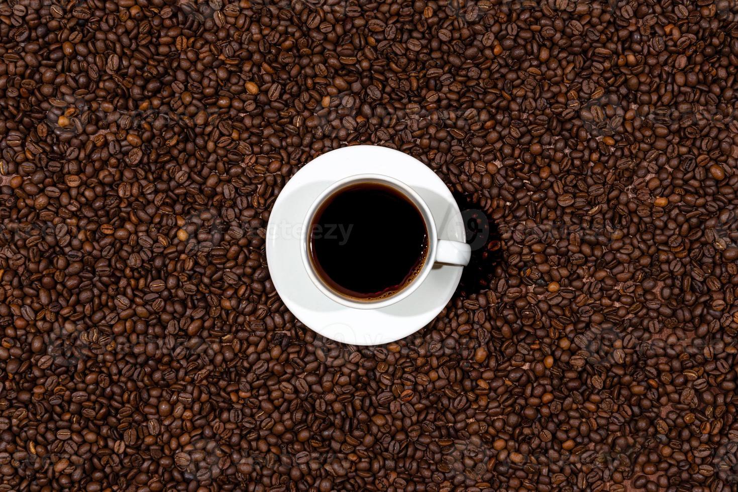 Draufsicht der weißen Kaffeetasse auf dem Kaffeebohnenhintergrund foto