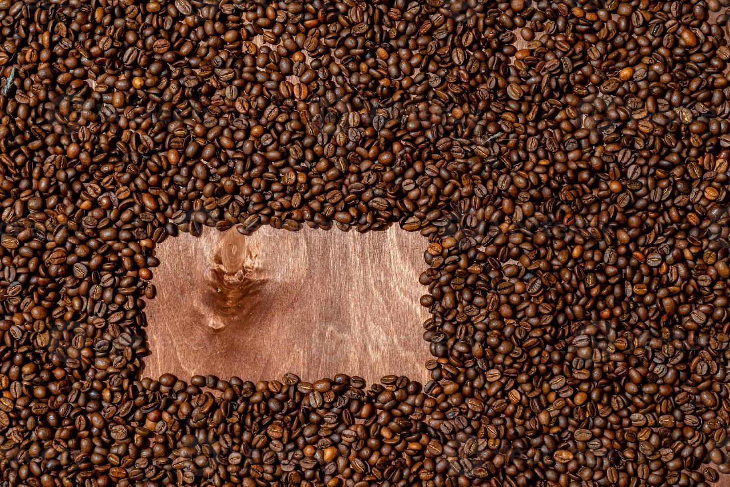 Hintergrundbeschaffenheit des dunklen Holzbretts und des Rahmens der Kaffeebohnen foto