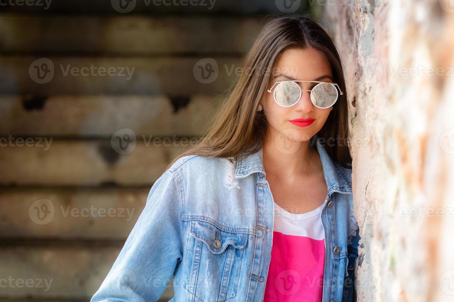 Außenporträt der schönen jungen Frau in der Sonnenbrille foto