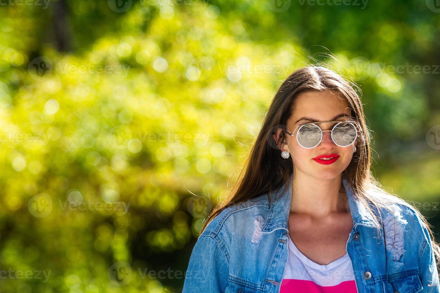 Außenporträt der schönen, emotionalen, jungen Frau in der Sonnenbrille foto