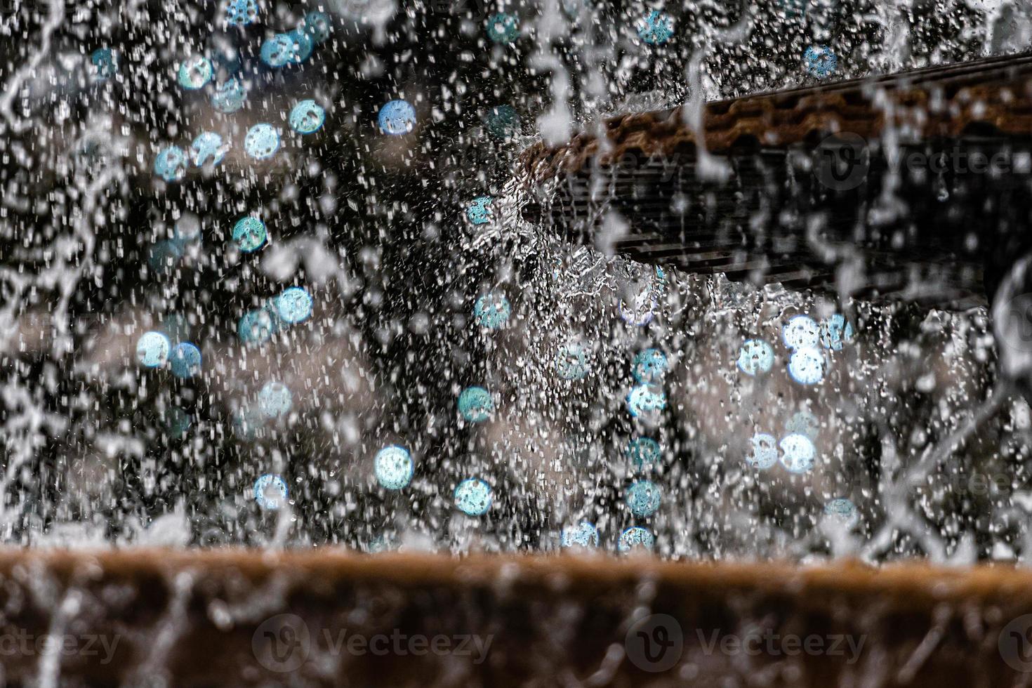 eine Nahaufnahme eines Wasserspritzers mit einer Weihnachtsgirlande in einem defokussierten Hintergrund foto