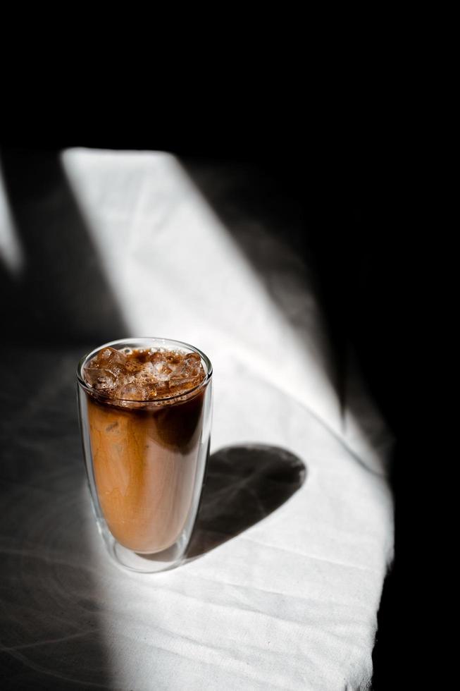 Glas Eiskaffee mit Milch auf dem Tisch foto