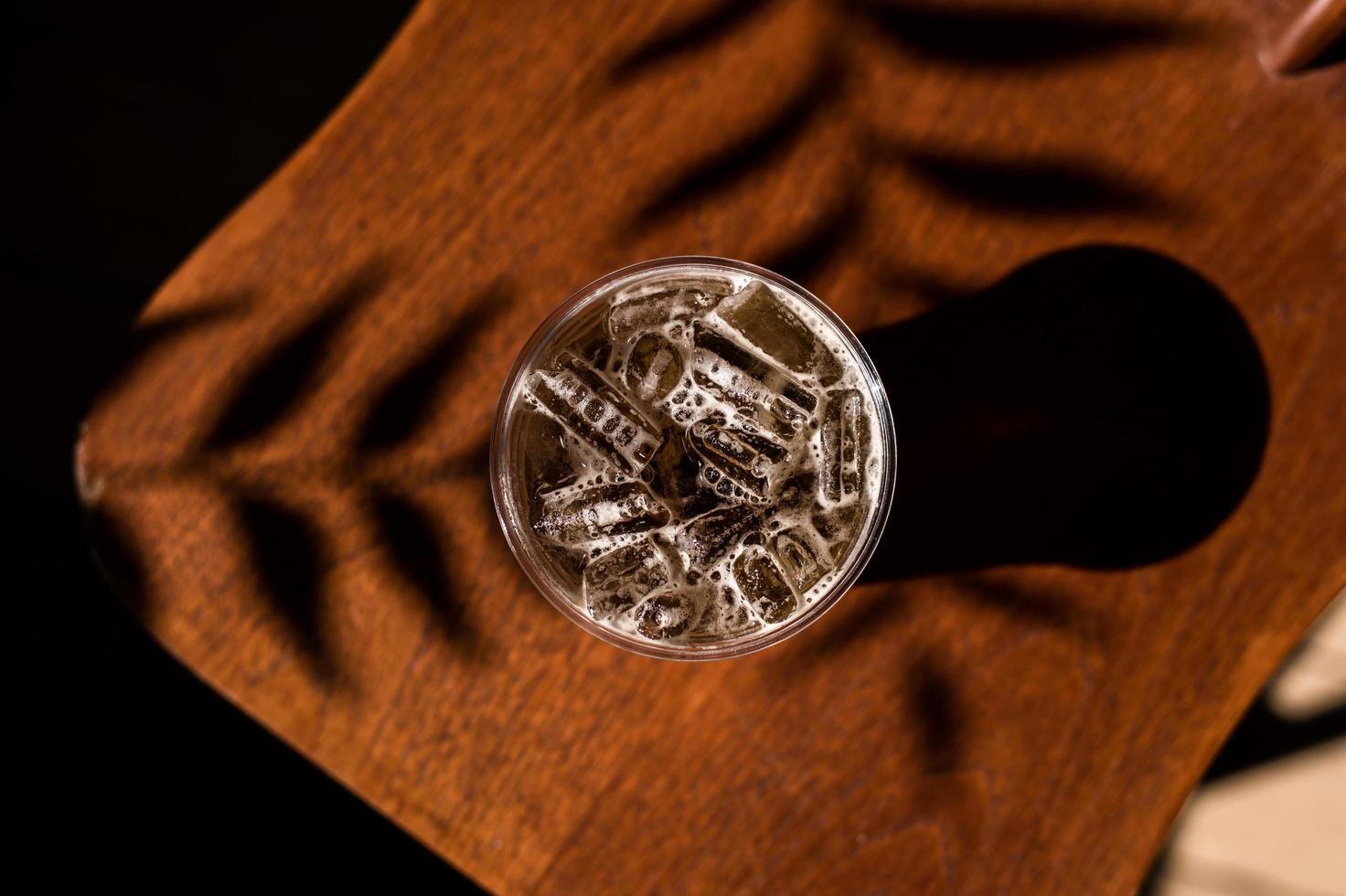 Glas Eiskaffee auf einem Stuhl mit Schatten foto