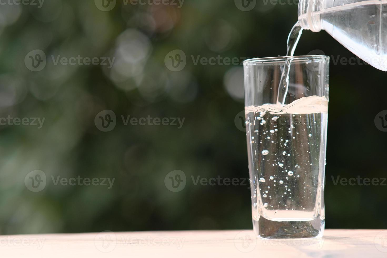 mineralisches Trinkwasser auf Holztisch und Wasser in Glas foto