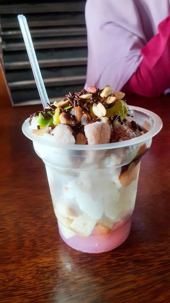 es podeng. traditionell Dessert von Kokosnuss Eis Sahne Eisbecher, Beliebt im Jakarta. gekrönt mit frisch Avocado, Tapioka Perlen, Schokolade Soße, Schokolade Sträusel und getoastet Erdnüsse. foto