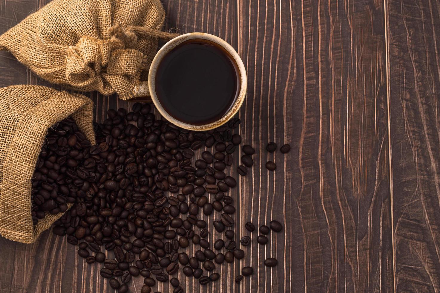 eine Kaffeetasse und Kaffeebohnen auf einem Holztisch foto