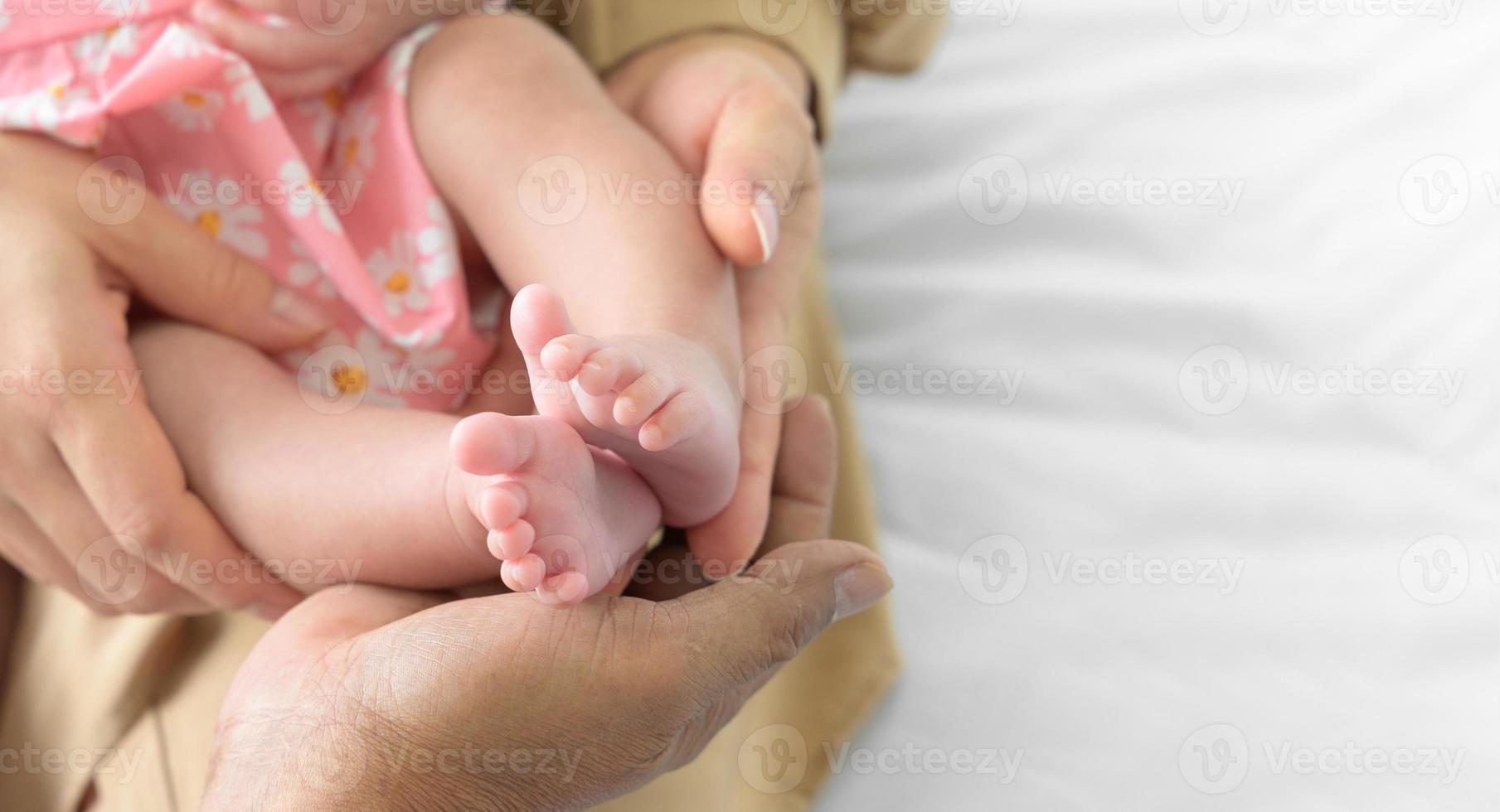 Neugeborene Baby Füße im Hände von Mutter und Vater foto