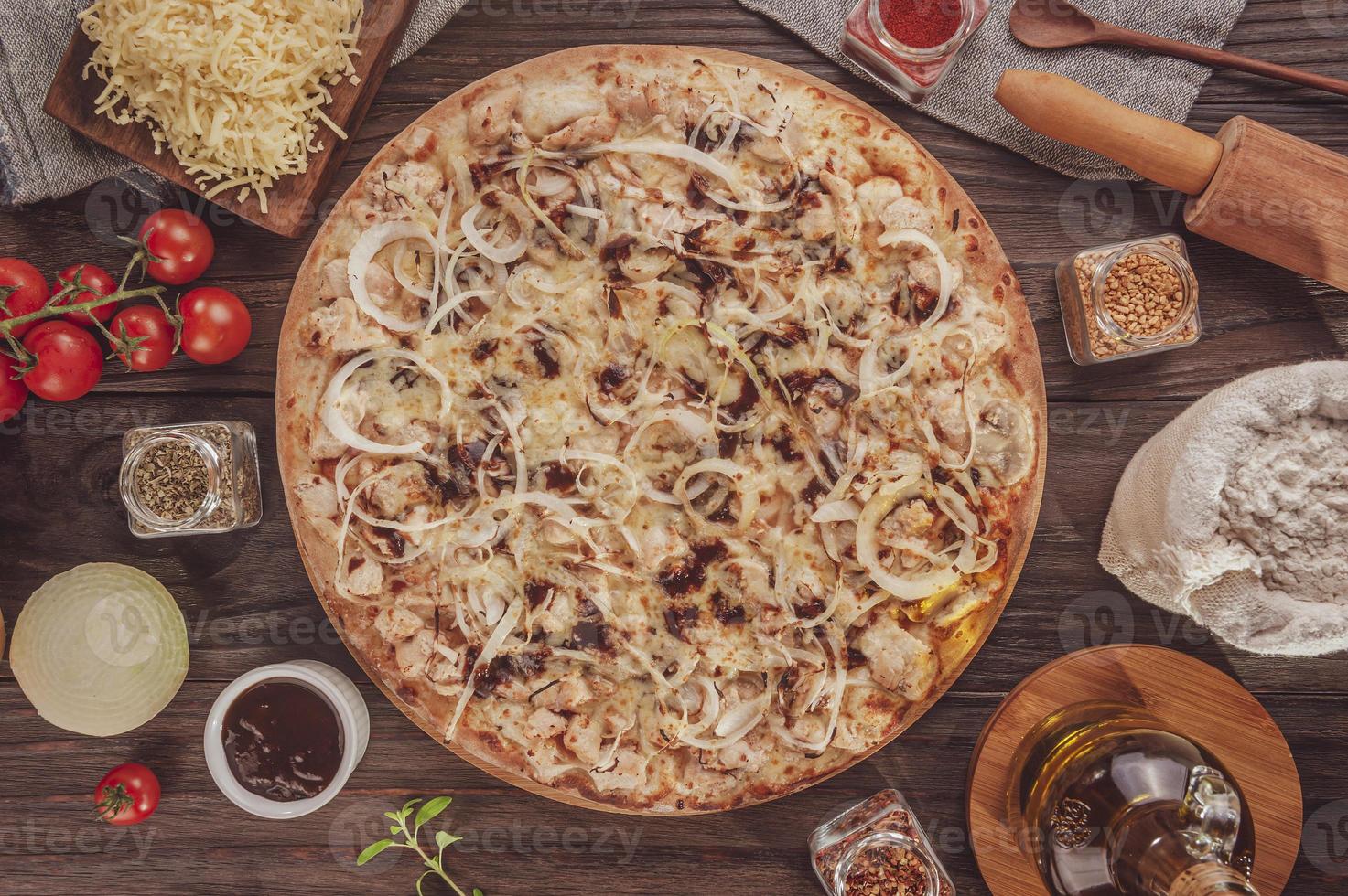 Pizza mit Barbecue-Sauce, gegrilltem Hähnchen, Zwiebeln und Oregano foto